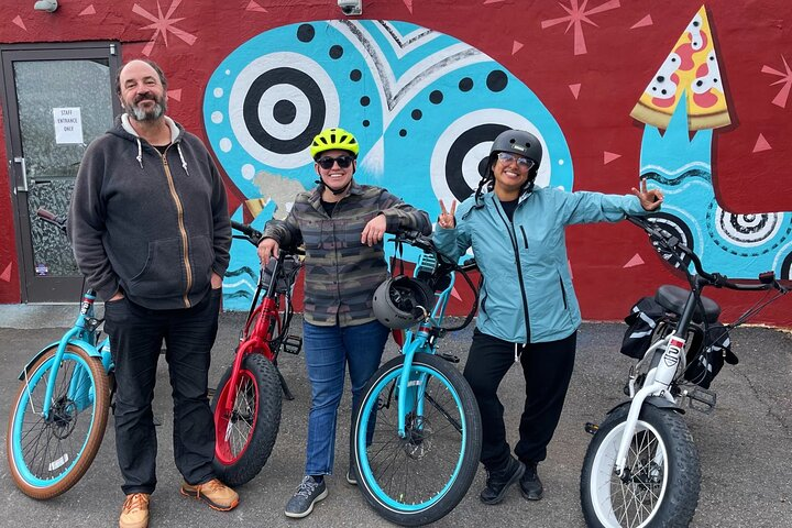 Tour group standing with e-bikes in front of a pizzeria